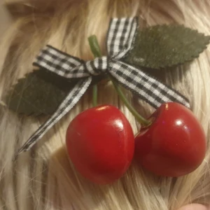 Hårspänne - 2-pack - Vackra Körsbär med rosett (REA) - Måtten på detta hårspänne är ca 8×6 cm.   Guldfärgad metall med blad o tyg, rosett i tyg och bär i trä. Oerhört vackra hårspännen Denna annons gäller bild 2 och 3, rutig och rosa/vit randig rosett. Önskas annan färg istället så säg till. 