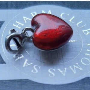 THOMAS SABO/ GLANSIGT HJÄRTA. - Thomas Sabo berlock, snyggt glansigt rött hjärta i fint begagnat skick.  Ask/påse ingår ej.  Kolla bilder o ställ ev frågor före bud.  Frakt tillkommer. 
