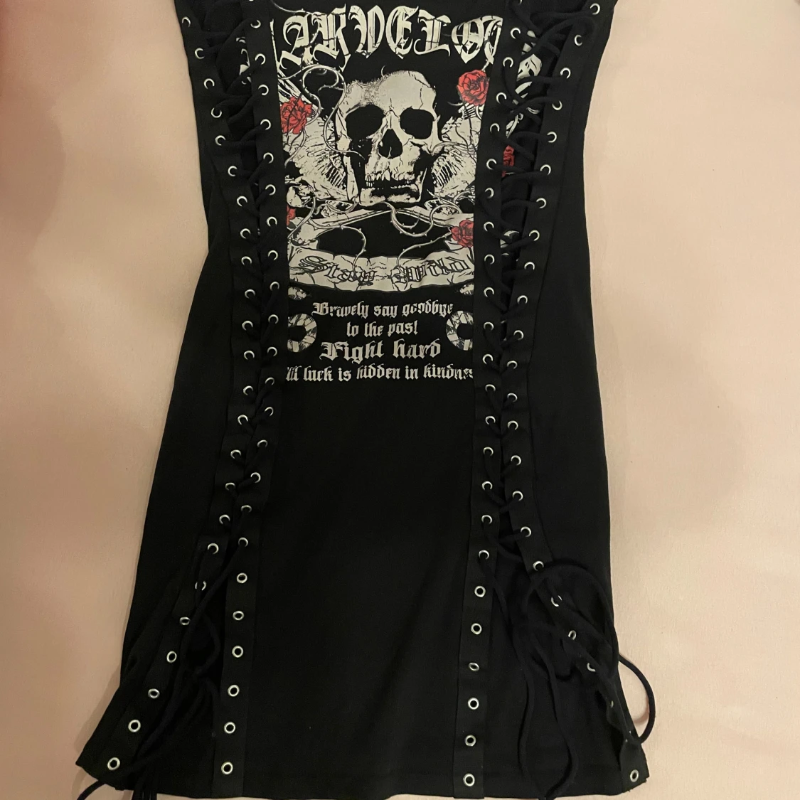 Svart klänning med dödskalletryck och snörning
