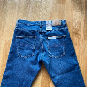 Nudie jeans grim Tim  - Helt nya(testade en gång) nudie Jeans i modellen grim Tim. Storlek 31/32 men efter lite justeringar på längden så är måtten på innerben 75 cm, höft till byxans slut 100 cm. Frågor/funderingar så är det bara att skriva. Priset är ej hugget i sten. Lapparna är inte kvar.