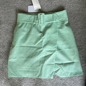 Grön kjol - Säljer denna super söta fräscha kjol med ett skärp från & other stories med lappen kvar då jag köpte en för liten storlek 