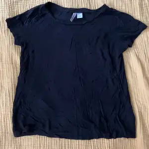 Svart tshirt i skönt fladdrigt material med en bröstficka. Från H&M divided. Inga fläckar eller defekter.
