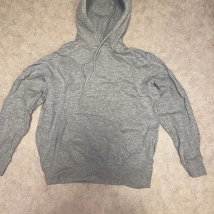 Grå hoodie - En simpel går blank hoodie. Storlek M men sitter nästan som en S. Osäker på märke då det inte står men skulle gissa på HM