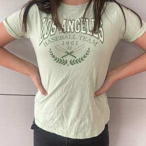 grön t-shirt med los angeles text
