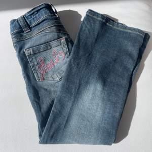 Säljer dessa jättefina jeans med fina rosa mönster på bakfickorna, midjemått: 59cm, längd: 77cm. Säljer på grund av att dem är för små för mig. 