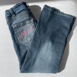 Jeans  - Säljer dessa jättefina jeans med fina rosa mönster på bakfickorna, midjemått: 59cm, längd: 77cm. Säljer på grund av att dem är för små för mig. 