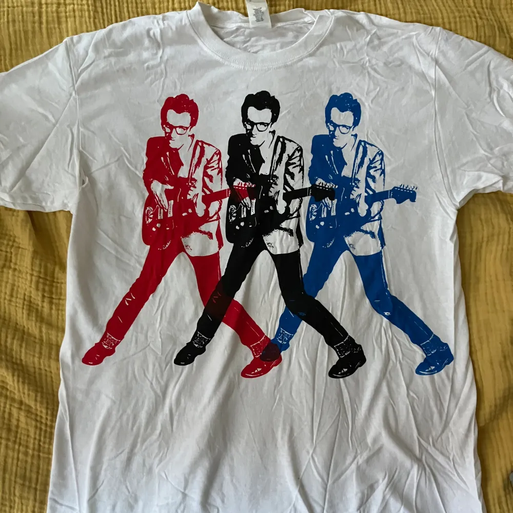 Elvis Costello tröja från Punkrockdisco som inte säljs längre. Den har en blå fläck på axeln och är lite gul i nacken. Storlek L men passar M också. T-shirts.