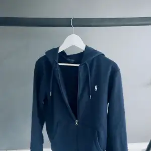 Ralph Laurent zip hoodie Lite trasig vid fickorna men annars bra marinblå färg köpt på Nk i Stockholm tyvärr finns inte kvitto kvar. Storlek s.         170 i längd