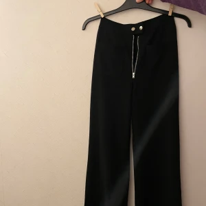 Kostymbyxor  - Svarta kostymbyxor med fickor fram 