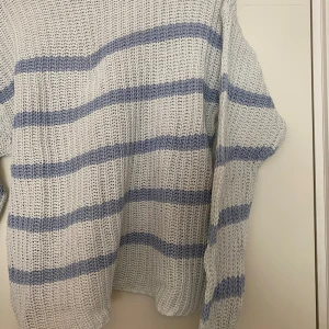 Stickad tröja - Stickad tröja med blåa ränder, kommer från lager 157 och är som helt ny. Köparen står för frakt