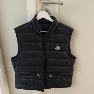 Moncler väst navy blue  - Moncler väst navy blue i storlek M säljs då den är för liten för mig. Köptes på NK i Stockholm 2022 för ca 8000 kr. Västen har knappt använts det senaste året då den som sagt är för liten.  Priset är ej hugget i sten! Tveka inte på att höra av er!