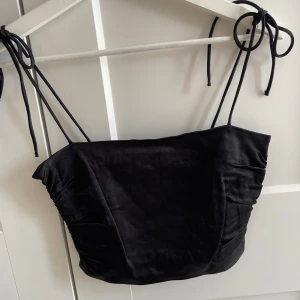 Svart söt topp - Helt oanvänd, kort, svart, söt topp med knytning på banden från Zara