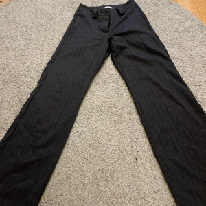 Kostymbyxor från Design By Si - Gråa kostymbyxor med låg midja och smala svarta ränder.⚡️I storlek XXS från Design By Si❤️‍🔥