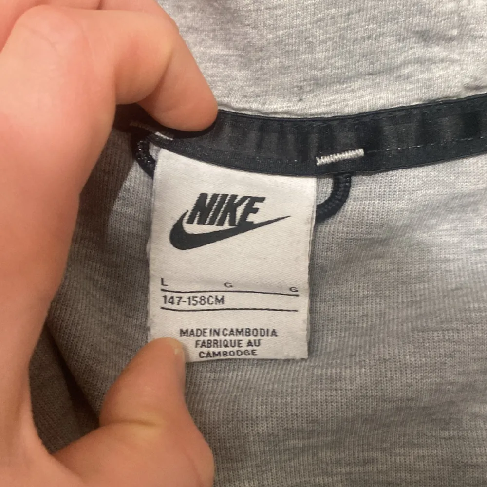 Nike tech fleece i färgen grå. Skicket är  7/10 då det är en liten slitning på vänster arm nere vid handen.. Hoodies.