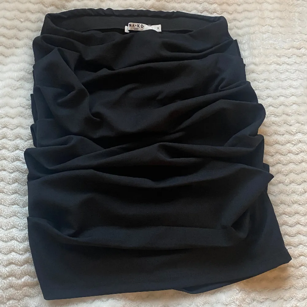 Snygg ”rynkad” kjol från NA-KD . Använd en gång. Formar figuren fint och är av ett stretchigt material .  . Kjolar.
