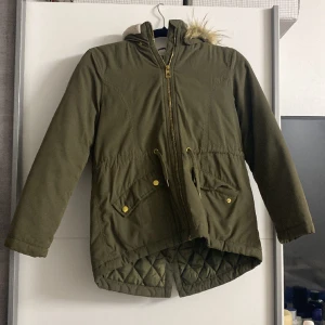 En olivgrön tjock jacka som värmer dig ordentligt  - En oliv grön jacka varm fin gullig mysig