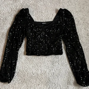 Glittrig topp - Säljer glittrig paljettopp med puffärm. Nyskick och köpt på Gina för 399kr. Storlek xs.