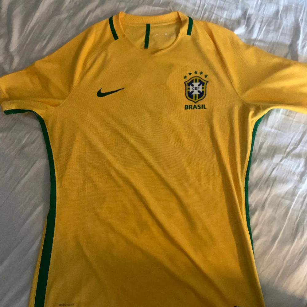 Fet brasilien tröja med neymar på ryggen! Perfekt till sommaren och 100% authentic! Tyvärr har nikeloggan börjat släppa lite men går nog lätt att limma! Storlek XL men sitter som L!. T-shirts.