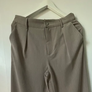 Beige/randiga kostymbyxor  - Kostymbyxor i beige. Använda en gång, så i nytt skick! För bättre bilder, kontakta mig🥰