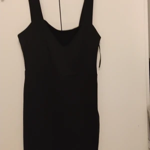 Svart fin klänningstl 40  med blixtlås i sidan och slits fram - Fin svart klänning från amisu storlek 40, dragkedja i sidan Stitch längst ner aldrig använt är i jättefint skick