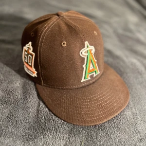 New Era Keps - Brun/grön/orange New era keps. Storlek 6 7/8 (54.9 cm). Nypris runt 500kr