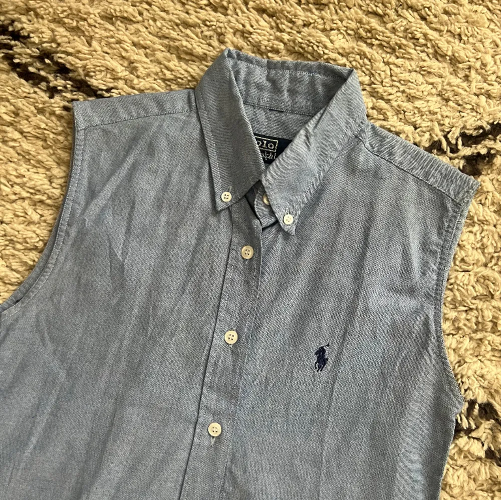 Ärmlös skjorta i ljusblå från Ralph Lauren🌹 Perfekt att ha u der en stickad tröja😍 Sparaamt använd! . Skjortor.