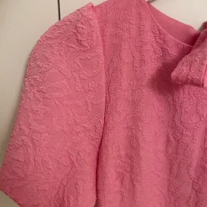 Fin sommarklänning från Vila - Storlek 36, passar även en som är 38. Rosa klänning med fina detaljer och  rosett på ryggen. Ord pris 599kr, säljer för 250kr. Endast använd vid 1 tillfälle, nytt skick. 