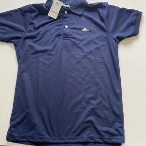 Blå Lacoste | picke - En mörkblå Lacoste picke i riktigt bra skick | 10/10 har haft på mig den en gång för att testa men inte annars. Säljer den för att den var för stor | nypris 500kr |  Mitt pris 210kr