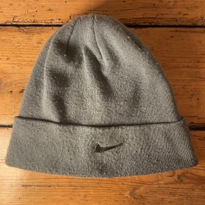 Nike silver mössa  - Grå Nike mössa med silver metall logga. Mycket skön och snygg mössa. Ej använt mycket, är i superbra skick. 10/10. 