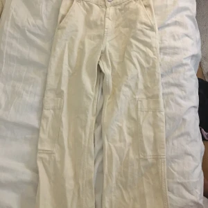 Beige cargo jeans - Jättefina straight/wide leg cargo jeans som tyvärr är för små. De är mid waist men man kan också ha dom lägre ner så det blir low waist. 