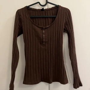 Kroppsformad topp - Brun stretchig tröja som sitter fint på kroppen. Materialet är mjukt och har inga brister. Använder den bara inte 