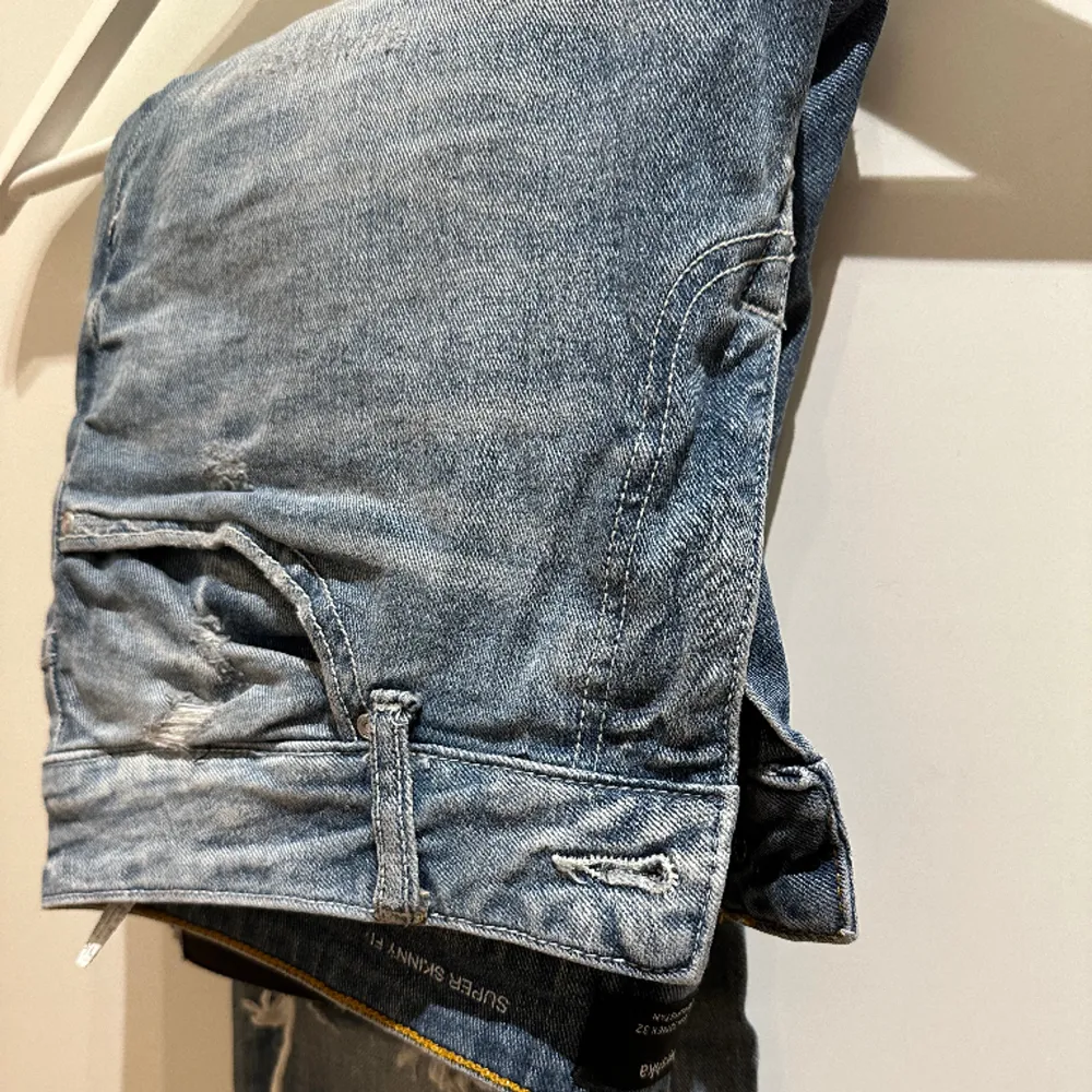 Bershkas super skinny blåa jeans i storlek 42 EUR. Däremot relativt stretchiga men sitter tight hela vägen ner till anklarna. Slitningar på knäna, hög kvalité och få andra förslitningar. Stil och komfort i ett! Förnya din look nu!. Jeans & Byxor.