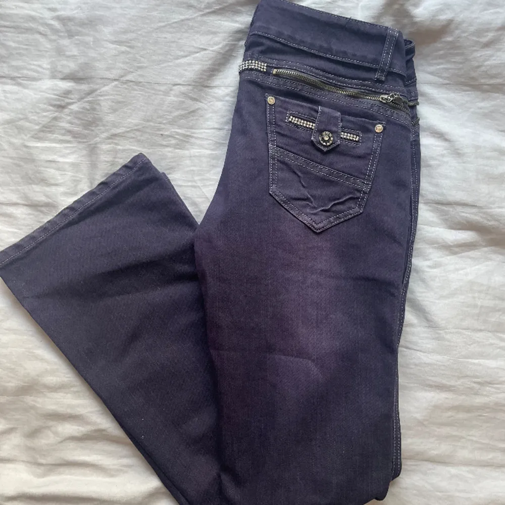 Sjukt coola lågmidjade jeans med häftig mörklila färg och coola detaljer i mycket gott skick! . Jeans & Byxor.
