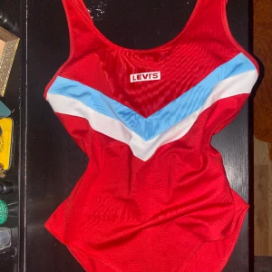 äkta Levi’s body - En superfin, klassisk, röd Levi’s body inköpt för 4-5 års sen, knappt använd och därför i nyskick. Perfekt till sommaren att ha under ett par snygga jeans eller liknande! Storlek M men kan passa som storlek S beroende på hur man vill ha passformen 😍