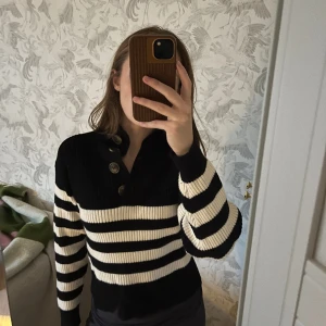 Stickad tröja från Mango - Superfin stickad tröja köpt på Mango för några år sen. Har hållt sig i väldigt fint skick! Tröjan är svart och vit randig med knappar vid halsen🤗