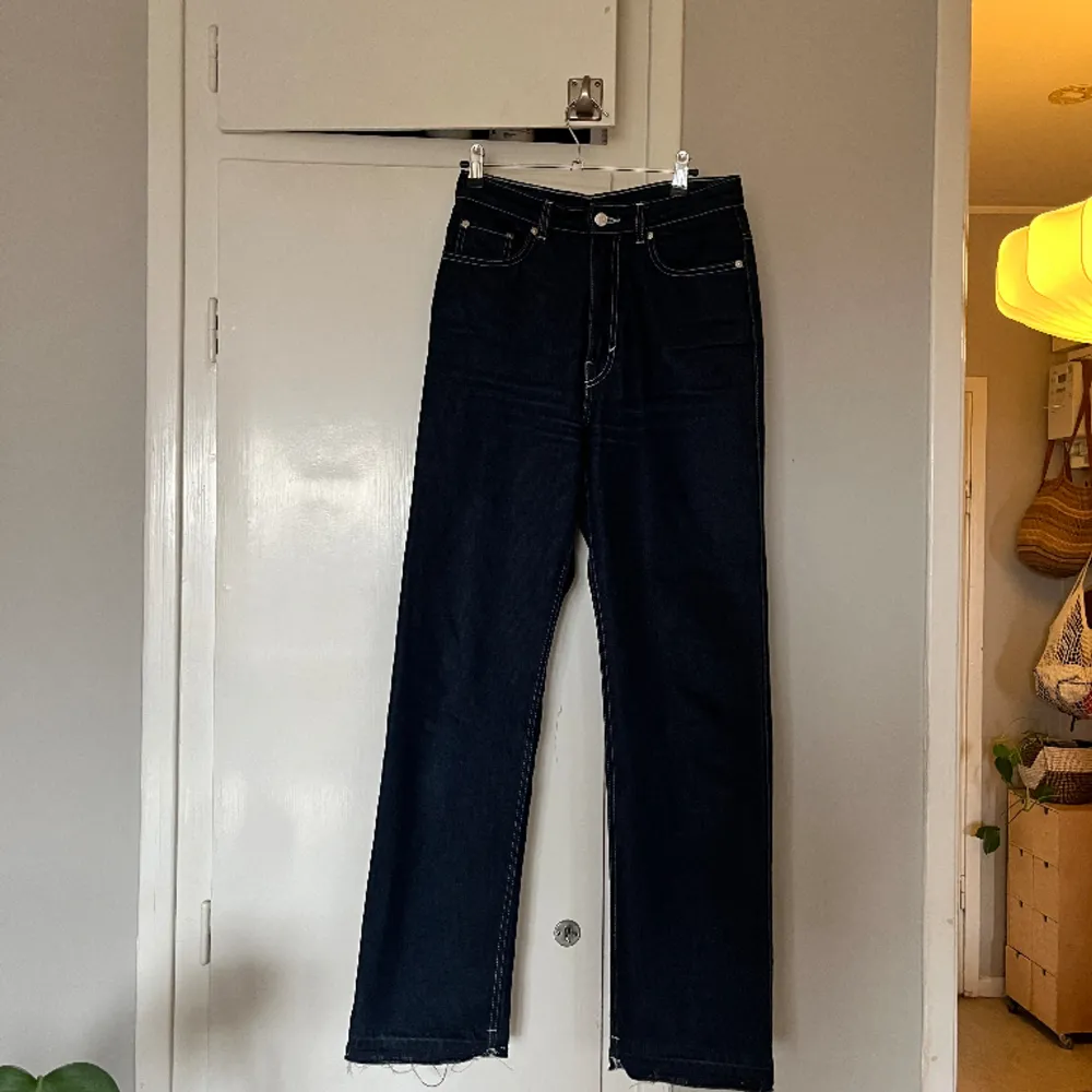 Jeans m vita kontrastsömmar i modellen Rowe från Weekday. Har fållat ner dem, men kan enkelt fållas upp igen. Strl 28/30 (32 som nedfållade). Fint skick, sparsamt använda!. Jeans & Byxor.