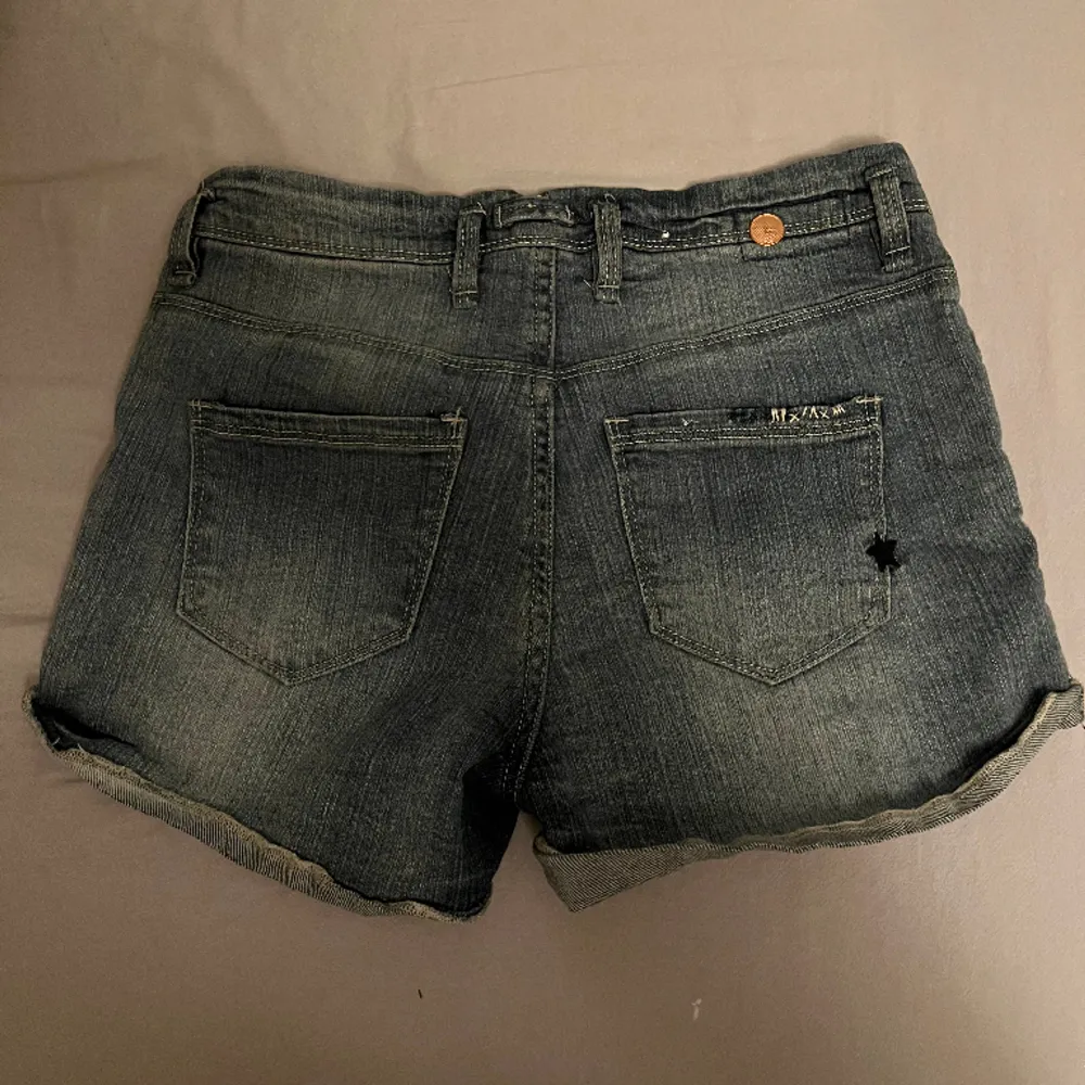 Så snygga grå/blå lågmidjade jeans shorts som tyvärr blivit för små och måste säljas, skicket är bra då jag endast provat dem och midjemåttet är 26!!. Shorts.