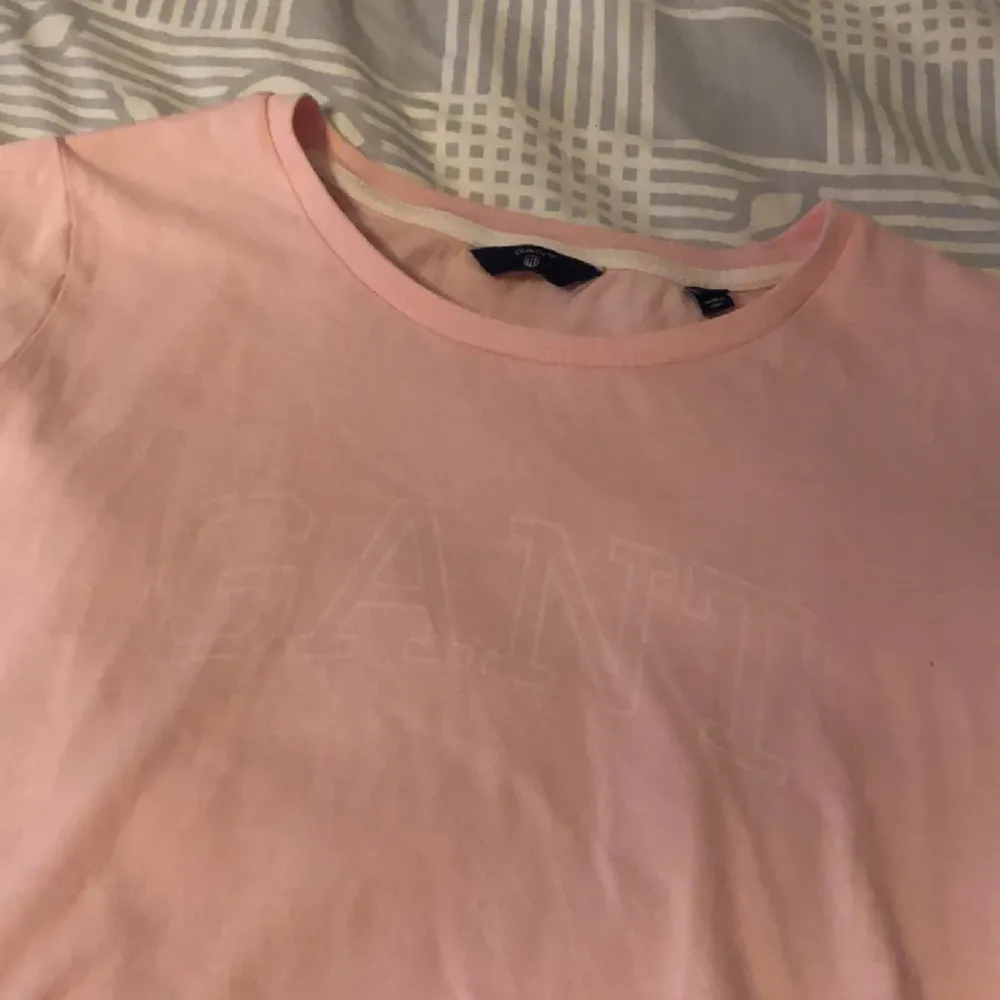 Rosa gant t-shirt. Tryck på framsidan som syns lite dåligt då det är i vitt. Sällan använd.. T-shirts.