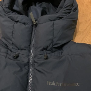 Peak Performance jacka dam  - Jättefin jacka, knappt använd. Finns dock ett pyttelitet hål på insidan som är lagat (se bild). Modell W Rival puffer.