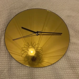 Klocka - Väggklocka i guldfärg, kan fungera som en spegel.   20x20 (cm)