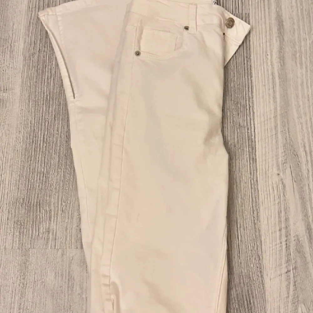 Vita jeans från sara med splittring vid botten. . Jeans & Byxor.