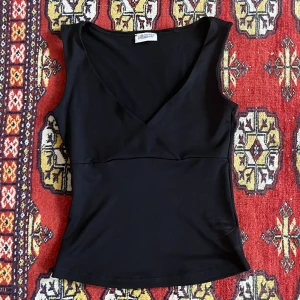 Svart topp - En svart topp från märket Pimkie. Står ingen storlek men skulle säga att det är en XS/S men materialet är väldigt stretchigt så passar en xs-m skulle jag säga :)