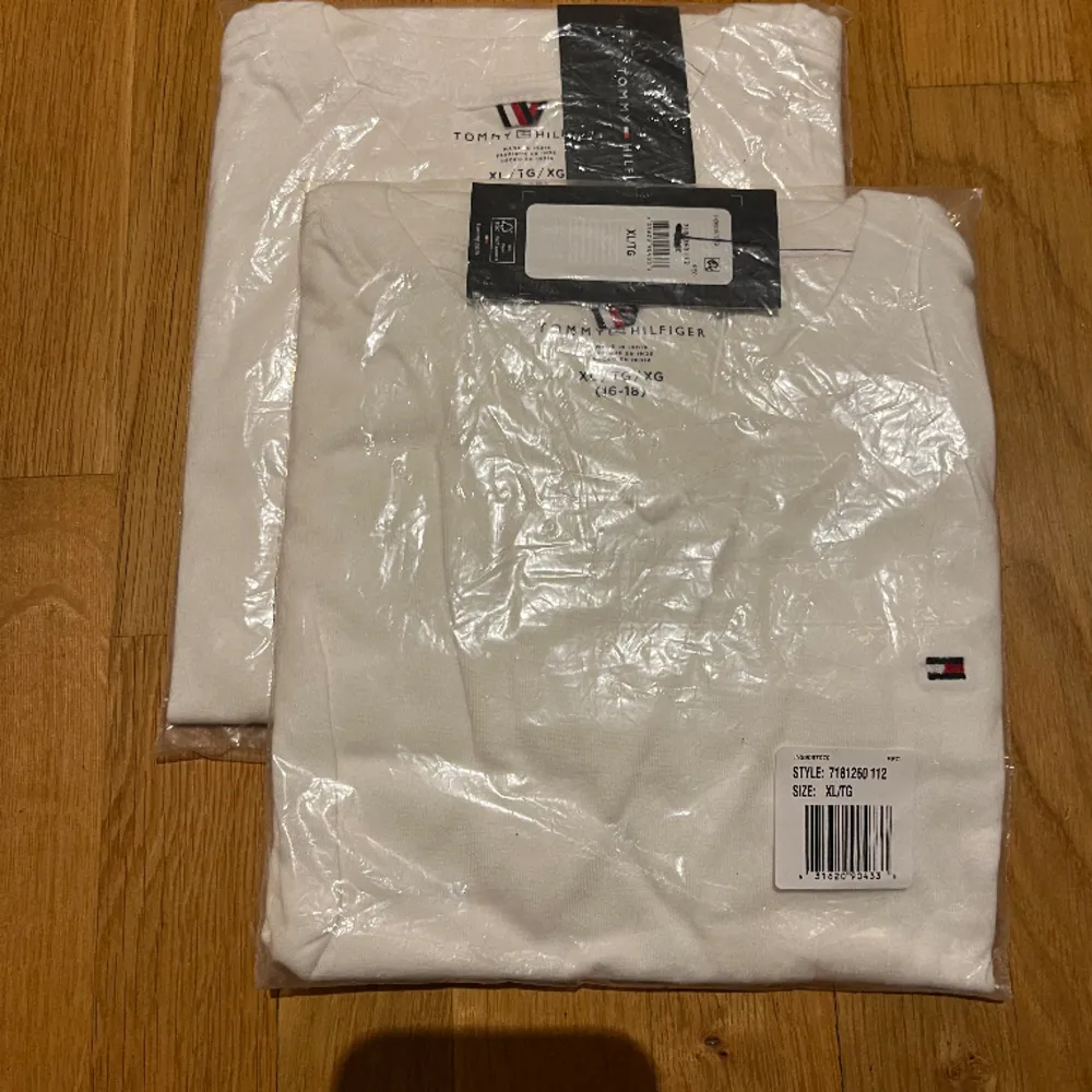 Tre vita Tommy Hilfiger t-shirts.  Två helt o öppnade och en helt o använd. . T-shirts.