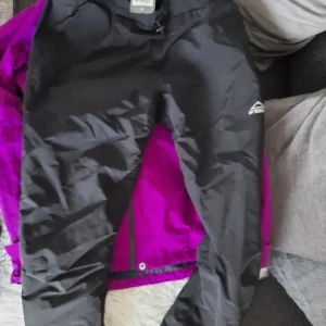 Regnjacka och byxa - En lila regnjacka och en svart regn byxa för 500. Är använda väldigt lite och är helt nya. Storlek 38 S