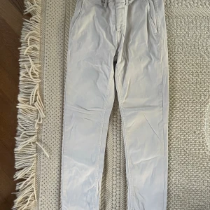 Replay byxor  - Säljer ett par ljusbeige Replay byxor i storlek 28. Säljes i befintligt skick. Har lite förslitningsskador.