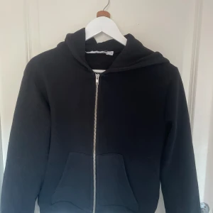 Hoddie - Croppad svart hoodie med dragkedia från lager 157. Storlek S. 