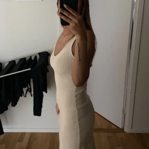 Klänning  - Säljer dena oanvända klänning som aldrig kommit till användning. Super fin och perfekt nu oxh sena sommarkvällar då den är stickad. Klänningen är köptes för 499