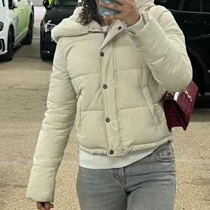 Hollister puffer jacket - En beige vinter pufferjacka med päls inuti. Passar perfekt till vintern och är enkel att matcha till olika outfits .