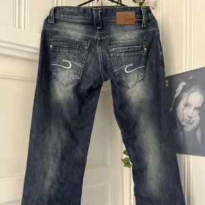 Mörkblå bootcut lågmidjade jeans  - För snygga lågmidjade mörkblå bootcut/utsvängda jeans med coola fickor och broderi detaljer från märket CROSS. Storleken står inte men passar som S/XS, pris går att diskutera ❤ Mått:  Midja- 35cm Innerbenslängd- 83cm Total längd- 100cm  