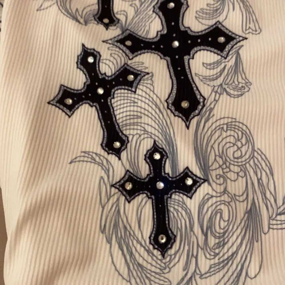 En svartvit supercool tröja med kors och vingar på!  I storlek s med en tajt passform! ❤️ Obs! Första bilden lånad från Pinterest men det är samma tröja!!! . Toppar.